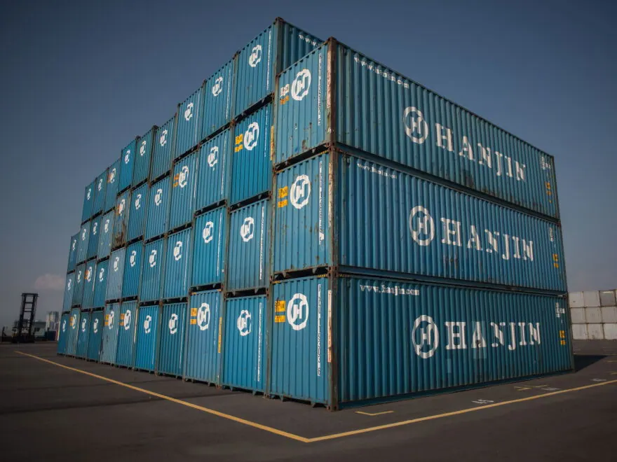 Stack of blue Hanjin shipping containers at a depot
