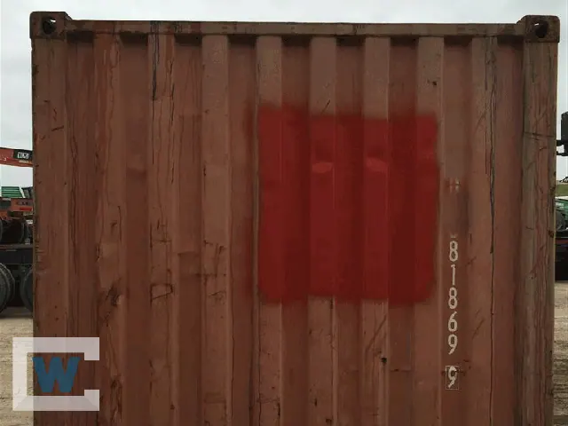 Close-up of a used container wall with a painted patch over prior repairs